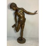 A large hollow cast bronze figure of a classical young male in loin cloth inspecting his foot