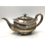 A George III silver teapot, with gadrooned rim and a band of horizontal reeded decoration to body,