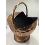 A Victorian copper Roman Helmet shaped coal scuttle with swing handle and front handle
