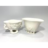 Two various blanc-de-chine Chinese porcelain libation cups, each moulded with peony blossom and