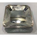 An art deco silver serving dish of square form with canted corners, reeded rim and geometric pierced