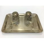 A silver inkwell of rectangular plain form with a pair of square glass and silver topped inkwells in