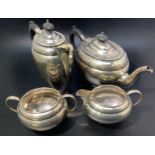 A four-piece silver tea set comprising teapot and hot water jug, both with ebonised handles and