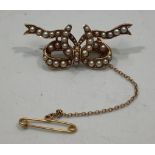 A 9ct gold and seed pearl brooch formed as a stylised bow, with safety chain, 3.5cm wide, 6.2g