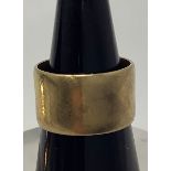 A 9ct gold wide wedding ring, weighing 7.7 grams, 9mm in width.