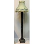 A Heavily carved Chinese hardwood standard lamp with a circular base on bird carved feet and a green