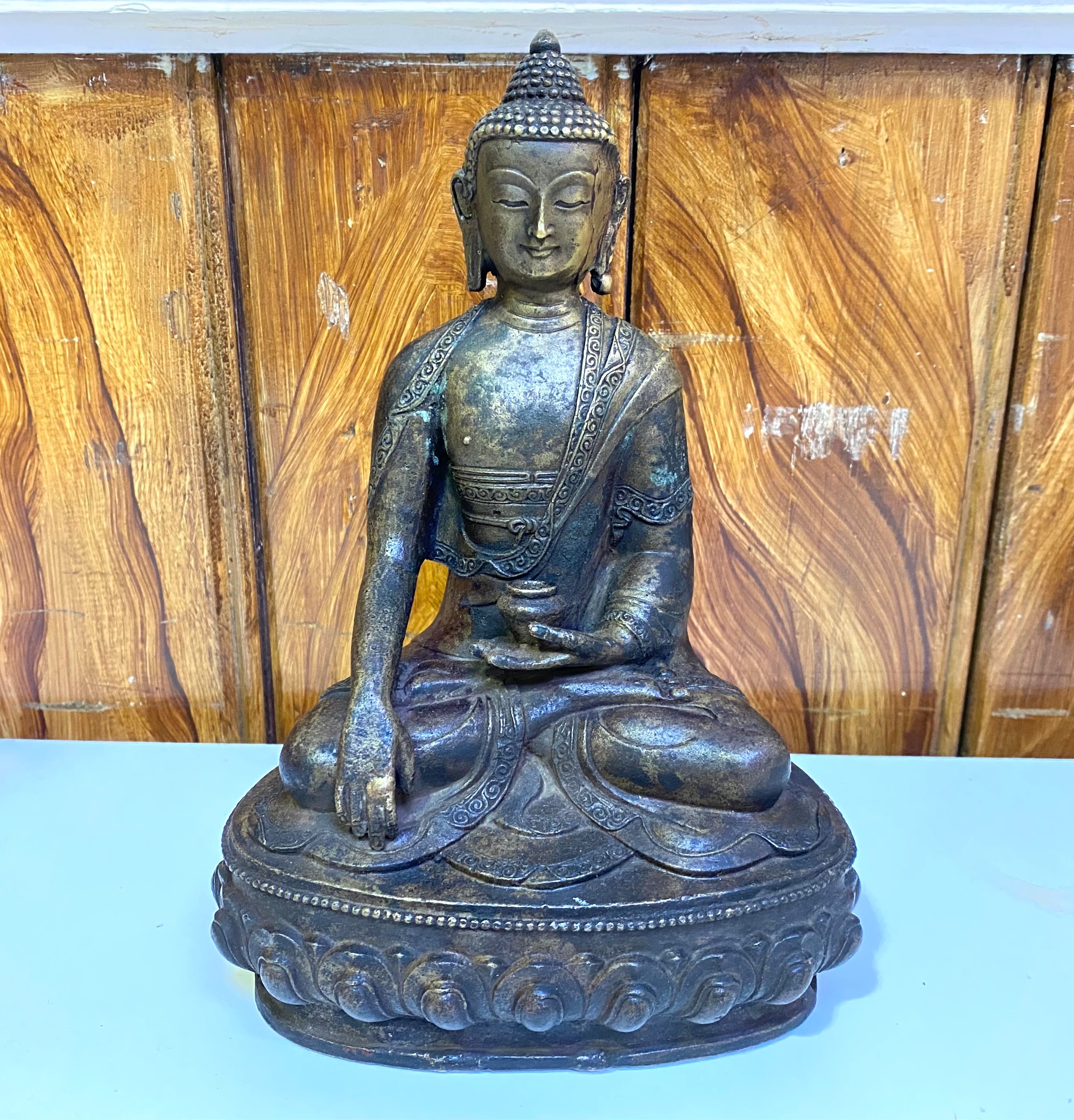An oriental cast bronze figure of Bodhisattva seated in Dyhanasana, with vase resting on left