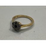 A yellow metal, tests as 18ct gold daisy cluster ring, the top centrally set with a sapphire