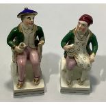 A pair of 19th century Staffordshire pottery seated dark haired men both in green coats, one with