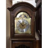A Georgian style oak longcase clock with arched hood, silvered dial with Roman numerals and moon