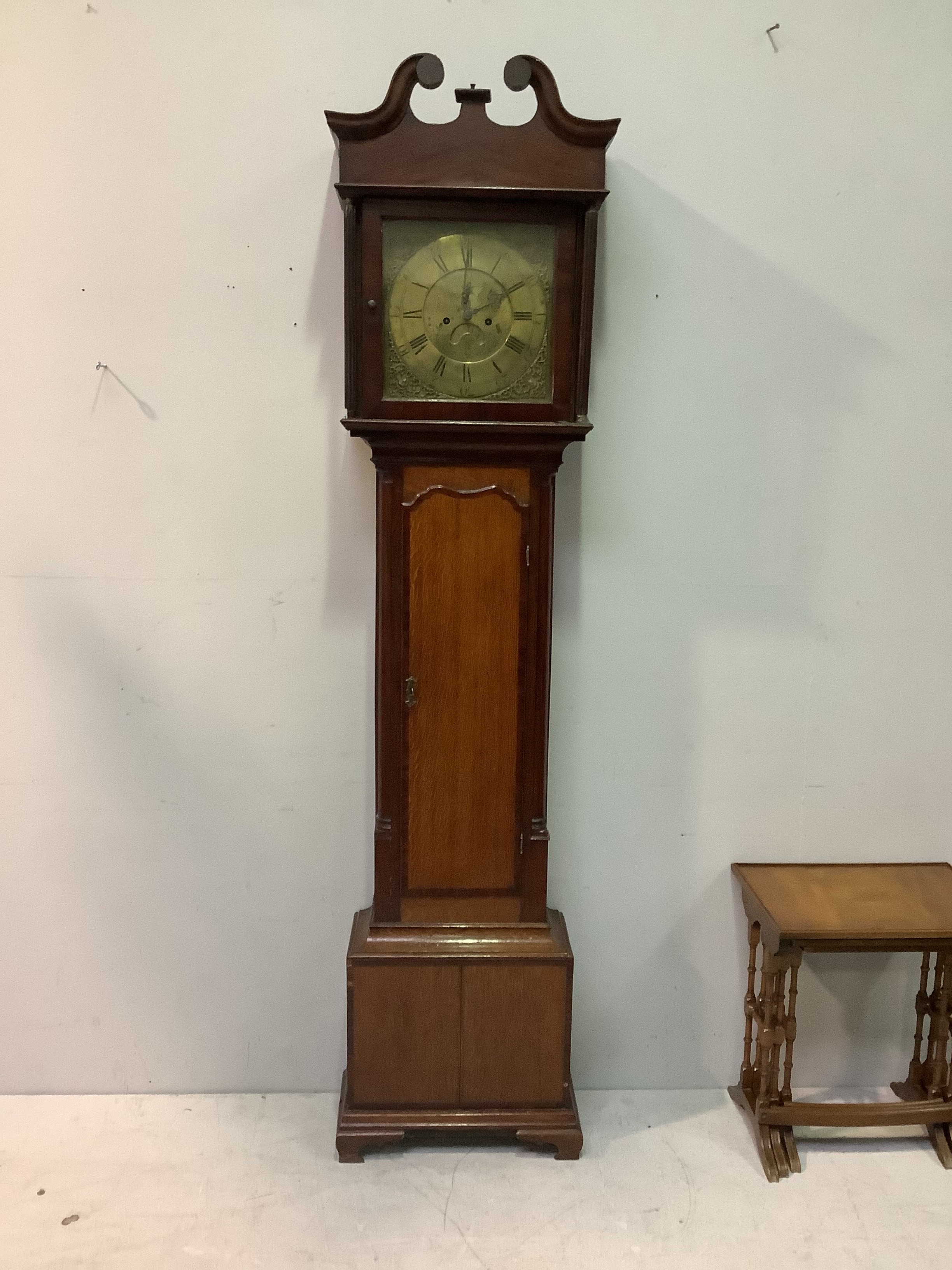An 18th century oak long case clock, the hood with swan neck pediment supported by doric columns,