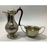 An Edwardian silver hot-water jug, of baluster form with reeded hinged cover, half-reeded body and