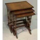 A nest of three mahogany tables with beech turned trestle style supports and curved stretchers