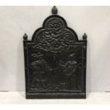 A large cast iron fire back depicting a man and woman under a tree, 77 x 51cm