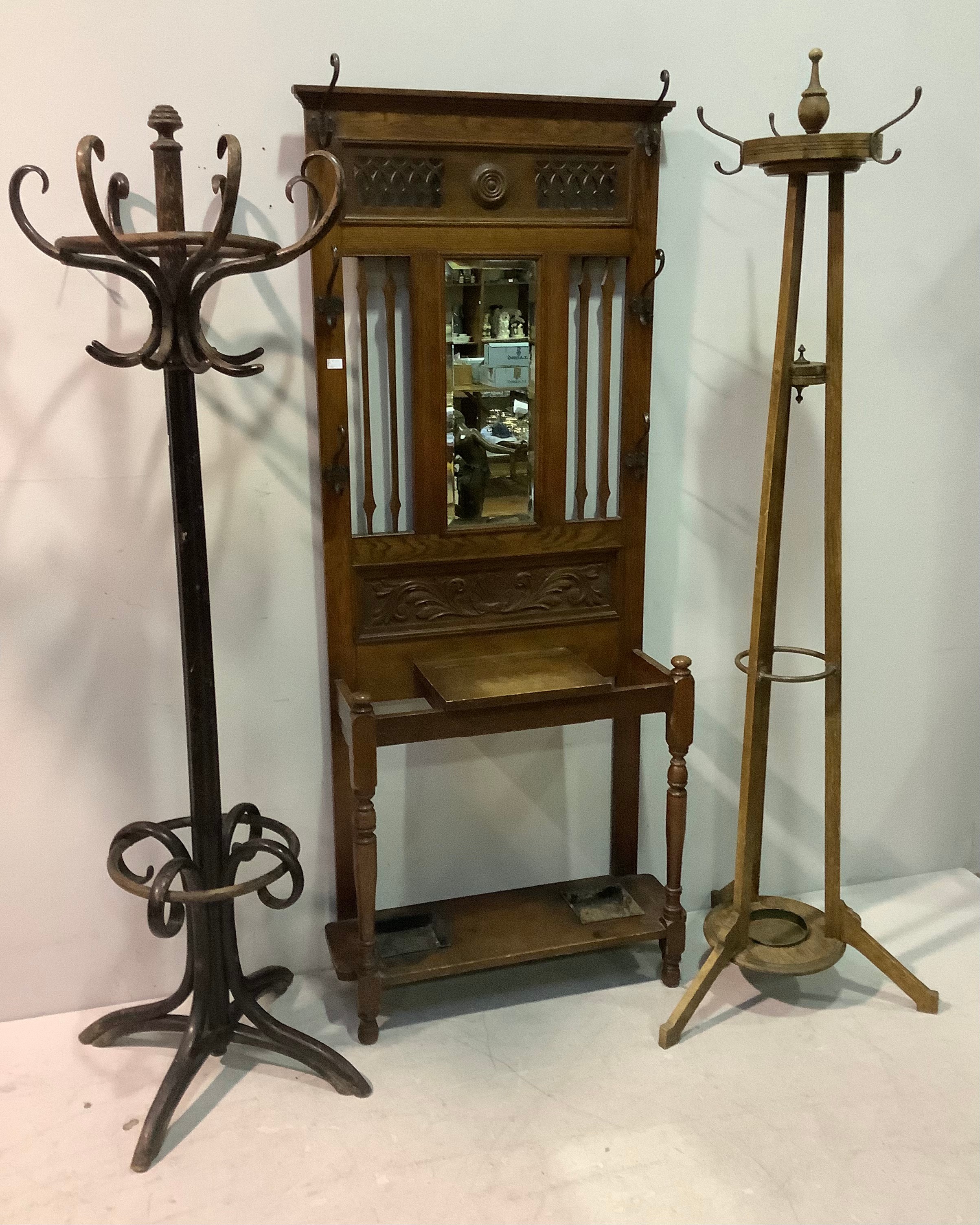 An Edwardian hall stand with central bevelled mirror and carved panel below, a lift top glove