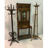 An Edwardian hall stand with central bevelled mirror and carved panel below, a lift top glove