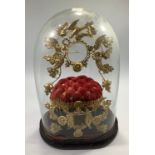 A marriage dome with gilt and red velvet cushioned interior, glass dome and black painted oval base,