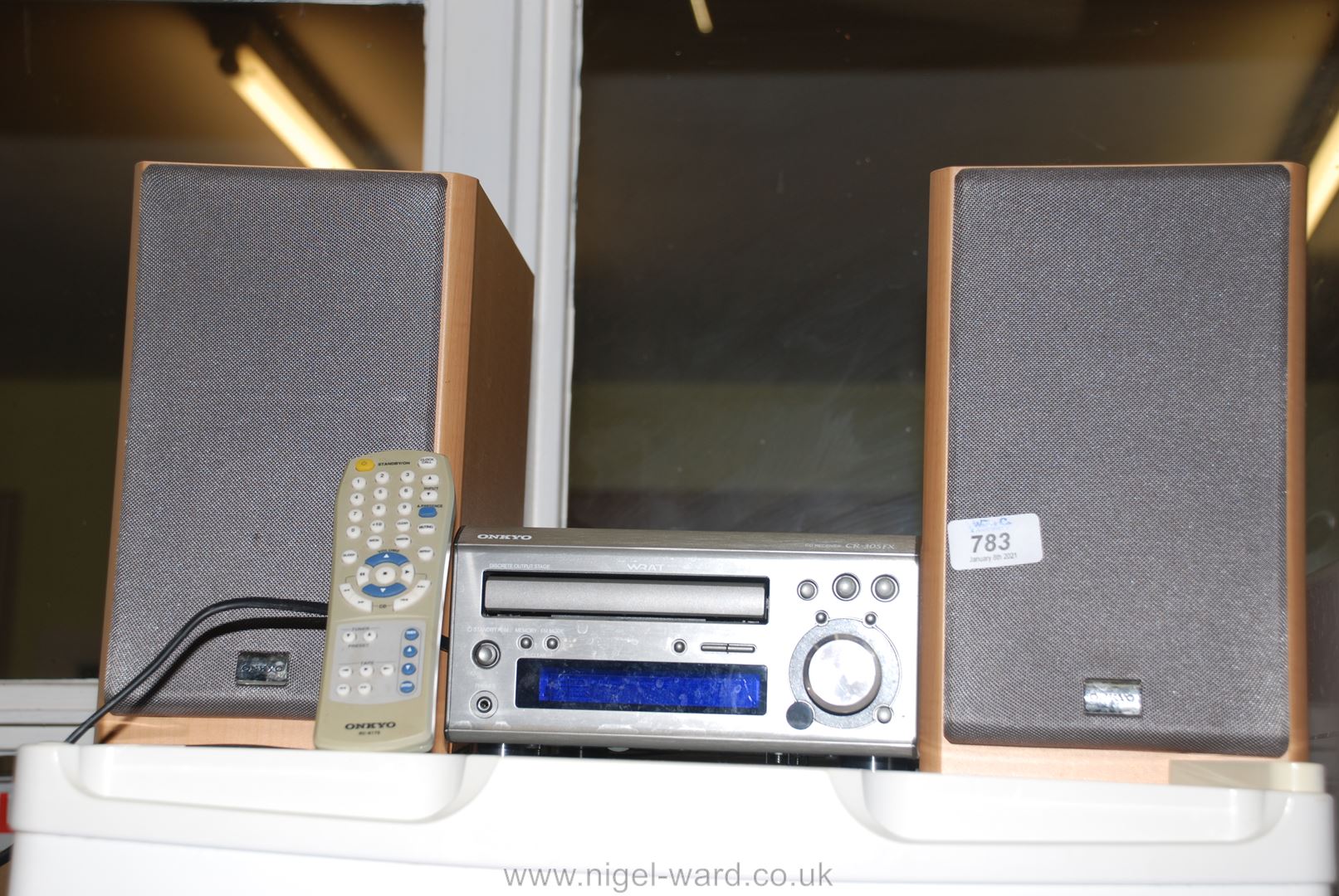 An "Onkyo" compact C.D., radio system with speakers and remote control.