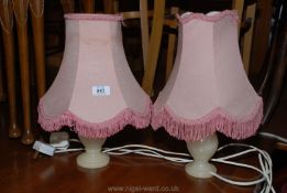 A pair of turned Alabaster table lamps with shades.