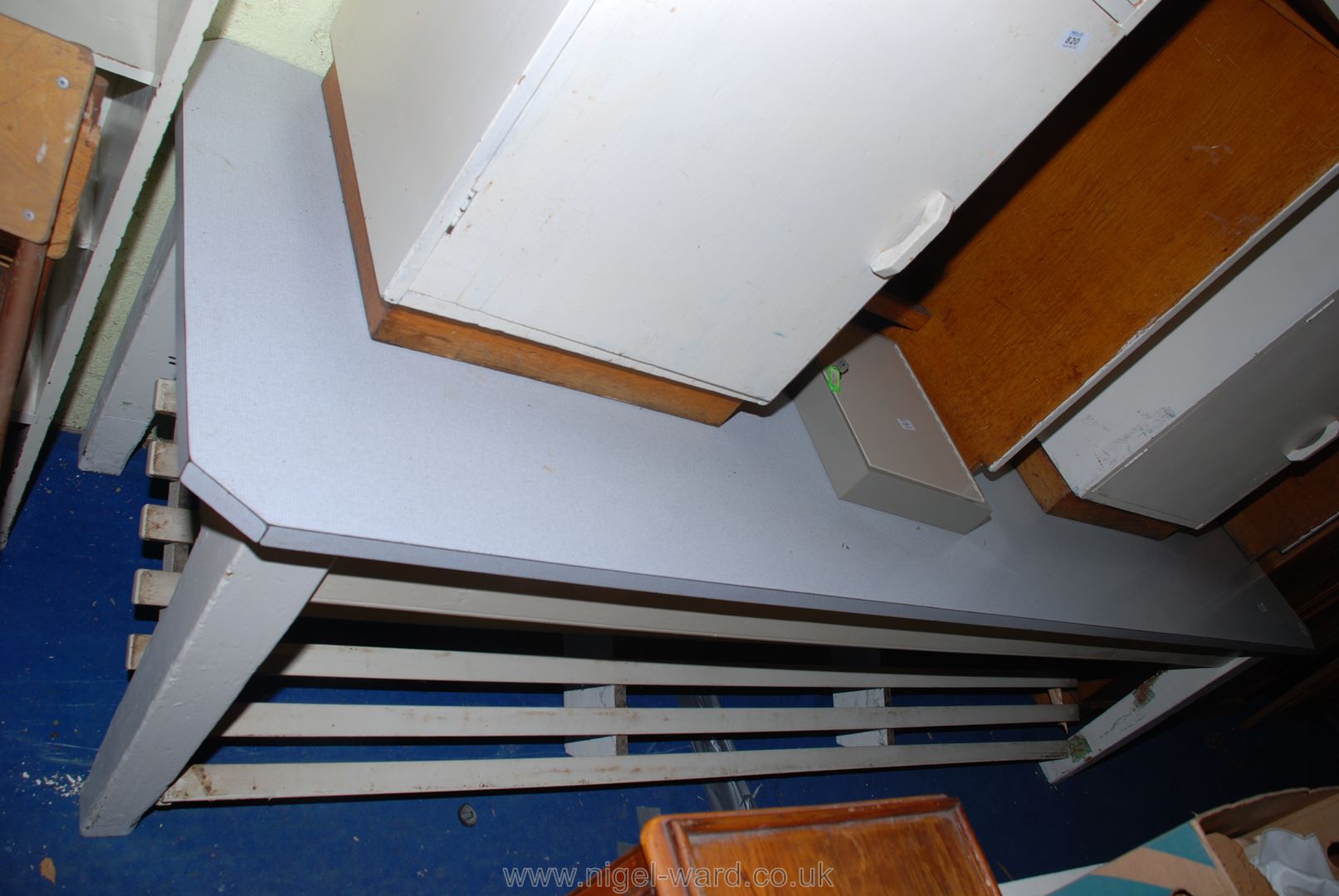 A "Melamine" topped refectory/kitchen table standing on tapered square legs with slatted lower