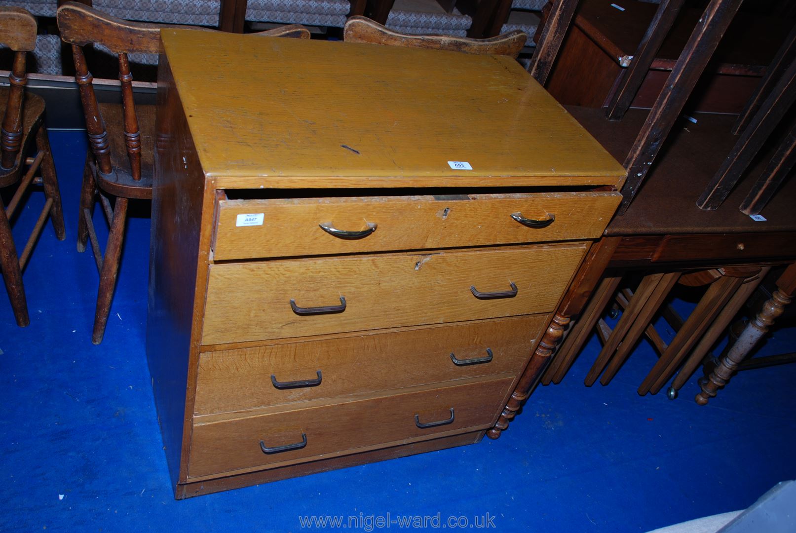 A light Oak finished chest of four long drawers, the top drawer having a fall front.