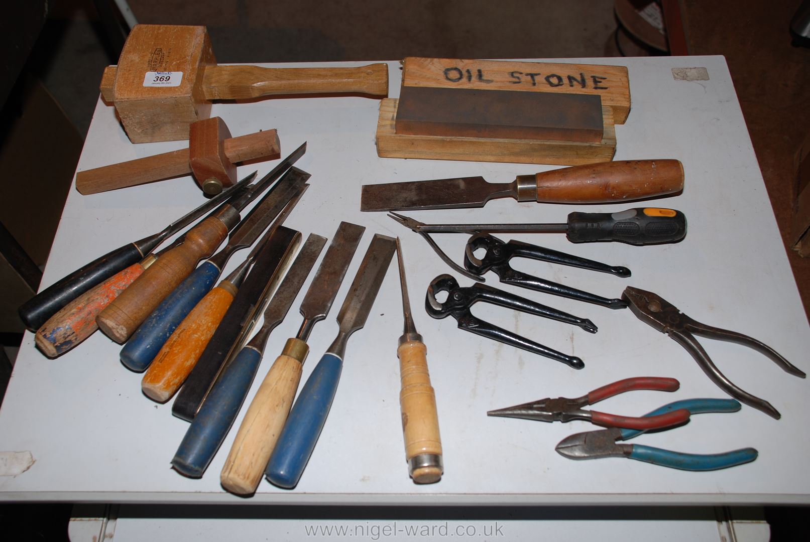 A box of various wood chisels, mallet, pliers, oil-stone, etc.