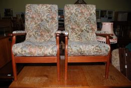 A pair of floral upholstered open-armed armchairs.
