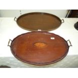 An oval mahogany tea tray with inlaid shell design to the centre and metal handles,