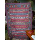 A brightly coloured crewel work rug or wall hanging, 47'' x 67".