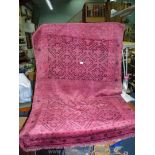 A hand woven Eastern rug, wool with possibly some silk, mainly deep pink with geometric pattern,