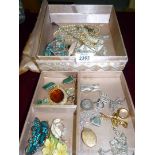 A silk box containing miscellaneous vintage costume jewelry, brooches, earrings etc.