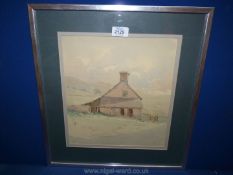 An unsigned framed and mounted watercolour of a house and outbuildings with rolling hills in the