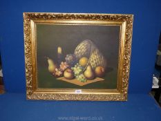 A gilt framed Oil on canvas depicting a still lief of fruit, candle and a basket,