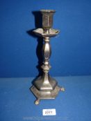 A white metal Candlestick with three lion paw feet, 11'' tall.