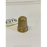 An appealing 9ct gold Thimble decorated with a frieze of trailing vines in relief,