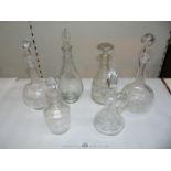 A quantity of decanters including long necked and etched and a small cut glass claret jug.