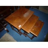 A Nest of three Oak occasional Tables standing on turned legs,