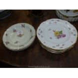 Three hand painted flower Limoges plates, cream with gold border,