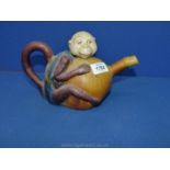 An unusual colourful Teapot in the form of a monkey, 9 1/2'' wide overall x 5 1/2'' high,