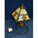 A Tiffany style electric table lamp with a square shape shade with geometric designs in green,