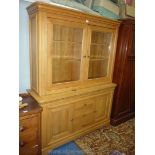 A contemporary light Oak living room Display Cabinet over a base with a flight of three central