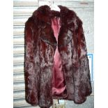 A short fur Jacket in dark red/black, size M.