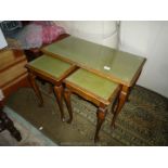 A Nest of three darkwood framed Tables having gold tooled green tops with glass top protectors and
