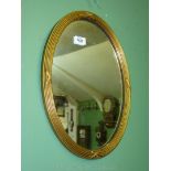 A small oval wooden gilt framed Wall Mirror, 17" x 12 1/2".