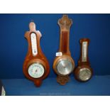 Three barometers including; one marquetry, one with leaf relief work.