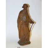 A 19th century continental carved fruitwood Figure of a bearded saint holding a book and supporting