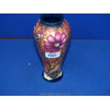 A Moorcroft Vase on orange ground decorated with Scabious type flower, 20 cms tall,