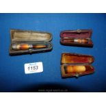 Three cased silver and Amber cheroot holders