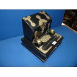 A brass bound ebonised stationery Desk Stand with two brass topped green glass inkwells,