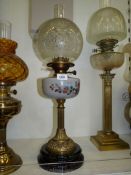 An oil lamp with black ceramic base, reeded pillar,